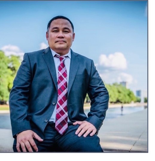 James Limbaga, Attorney at Law, standing outdoors in a suit